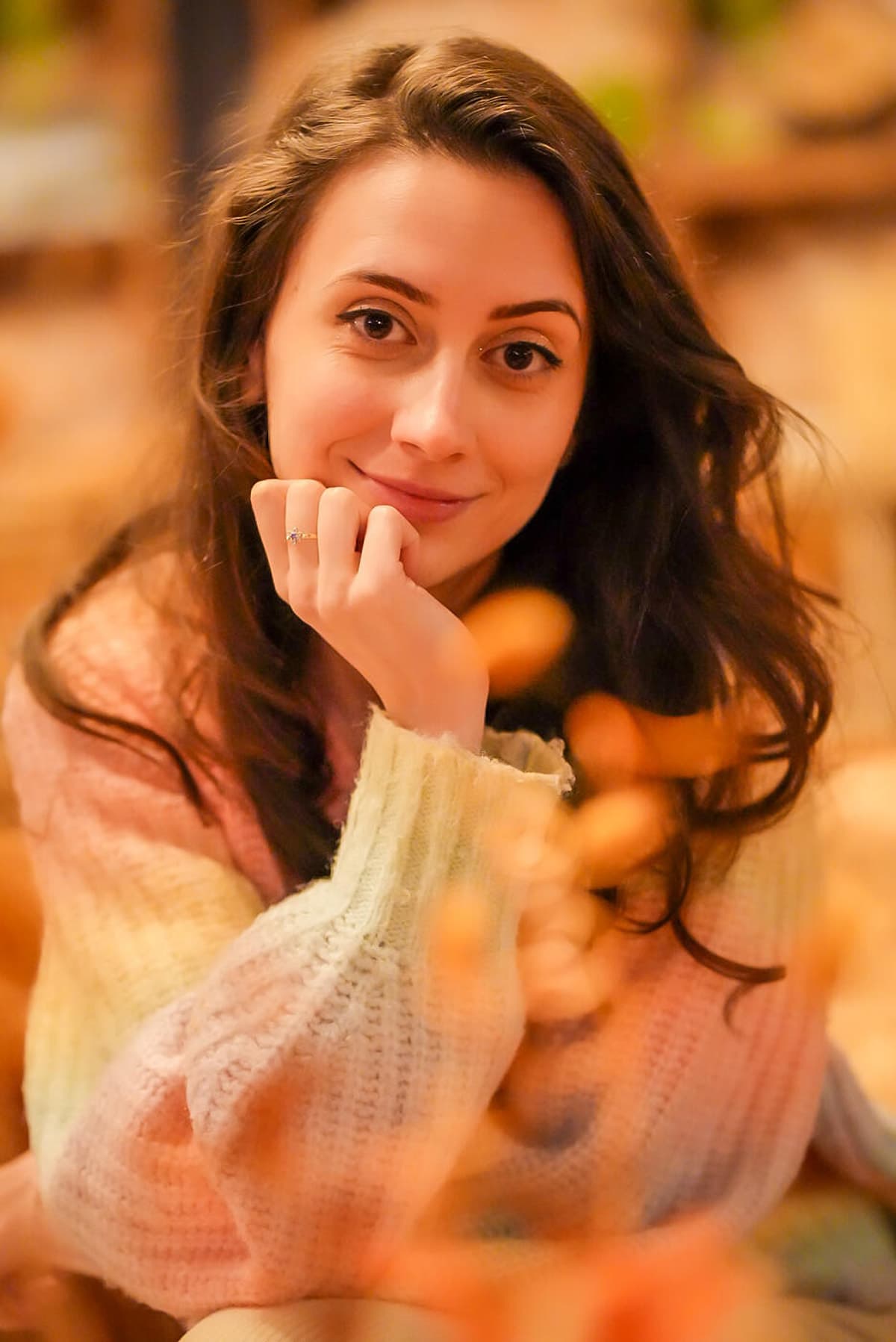 Portret de femeie cu părul ondulat, în pulover pastel